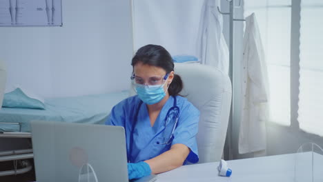 Krankenschwester-Tippt-Mit-Medizinischen-Handschuhen-Am-Laptop