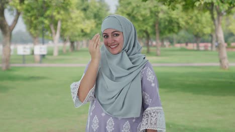 Glückliche-Muslimische-Frau,-Die-Adaab-Im-Park-Macht