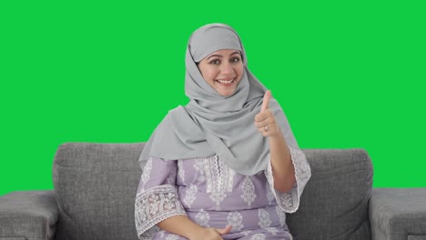 Fröhliche-Muslimische-Frau-Zeigt-Daumen-Hoch,-Grüner-Bildschirm