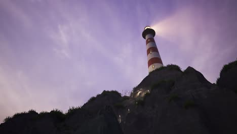 Beam-of-light-from-lighthouse-rotating-over-the-sea-during-sunset.-Tall-tower-on-the-small-island.-The-building-serves-as-a-navigational-aid-for-maritime-pilots-during-night-time.-Loopable-animation.