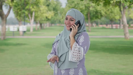 Mujer-Musulmana-Seria-Hablando-Por-Teléfono-En-El-Parque