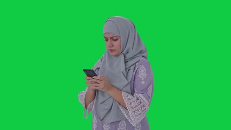 Angry-Muslim-woman-typing-on-phone-Green-screen