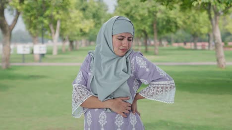 Muslimische-Frau-Leidet-Unter-Rückenschmerzen-Im-Park