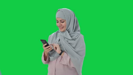 Happy-Muslim-businesswoman-using-phone-Green-screen