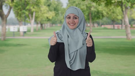 Happy-Muslim-woman-showing-thumbs-up-in-park