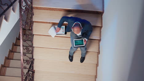 Top-view-of-manager-comparing-information-from-tablet-overtime