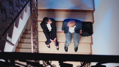 Top-view-of-overworked-businesspeople-talking-on-stairs