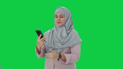 Glückliche-Muslimische-Geschäftsfrau,-Die-über-Einen-Videoanruf-Auf-Grünem-Bildschirm-Spricht