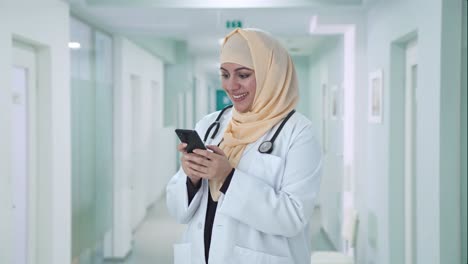 Glücklicher-Muslimischer-Arzt,-Der-Jemandem-Am-Telefon-Eine-Nachricht-Sendet