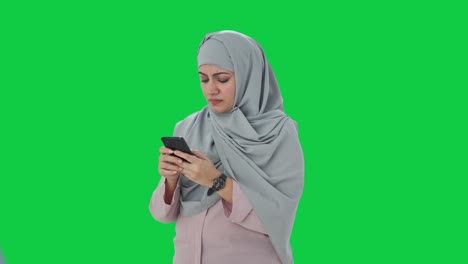 Angry-Muslim-businesswoman-typing-on-phone-Green-screen