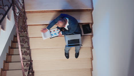 Top-view-of-office-executive-checking-reports-from-clipboard