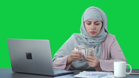 Triste-Empresaria-Musulmana-Contando-Dinero-En-Pantalla-Verde