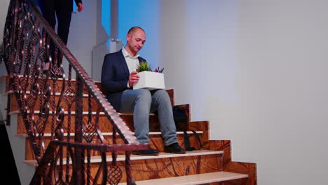 Desperate-businessman-being-fired-sitting-on-stairs