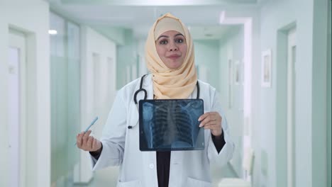 Glücklicher-Muslimischer-Arzt,-Der-Dem-Patienten-Den-Röntgenbericht-überprüft