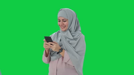 Feliz-Empresaria-Musulmana-Enviando-Mensajes-En-La-Pantalla-Verde-Del-Teléfono