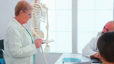Médico-Radiólogo-Sosteniendo-Una-Presentación-Usando-Esqueleto-Humano