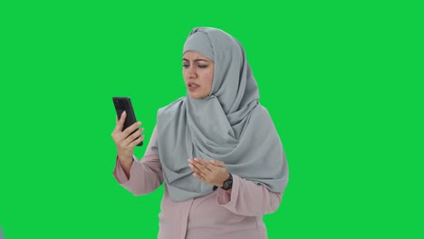 Angry-Muslim-businesswoman-talking-on-video-call-Green-screen