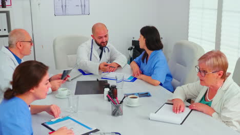 Medical-expert-talking-with-medical-staff-during-healthcare-meeting