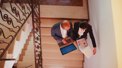 Top-view-of-businessman-holding-laptop-discussing