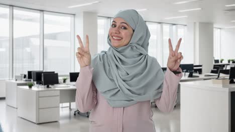 Glückliche-Muslimische-Geschäftsfrau,-Die-Siegeszeichen-Zeigt