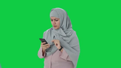 Angry-Muslim-businesswoman-using-phone-Green-screen