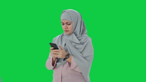 Wütende-Muslimische-Geschäftsfrau,-Die-Nachrichten-Auf-Dem-Grünen-Bildschirm-Des-Telefons-Sendet