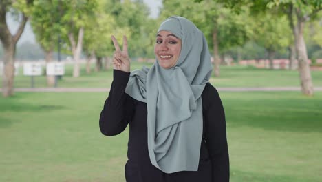 Glückliche-Muslimische-Frau-Zeigt-Siegeszeichen-Im-Park