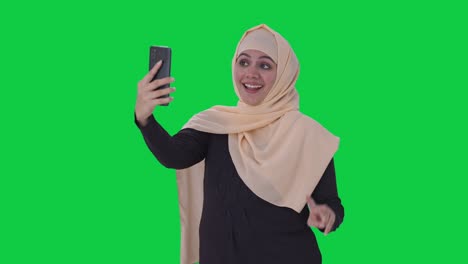 Glückliche-Muslimische-Frau,-Die-Auf-Den-Grünen-Bildschirm-Für-Selfies-Klickt
