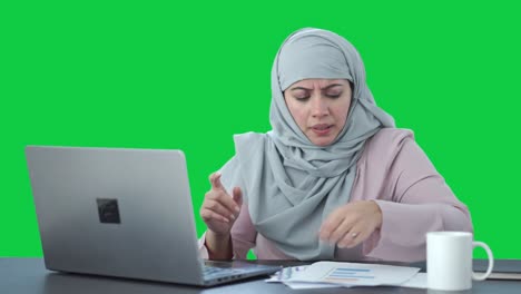 Angry-Muslim-businesswoman-doing-online-meeting-Green-screen