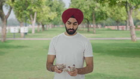Hombre-Indio-Sikh-Contando-Dinero-En-El-Parque