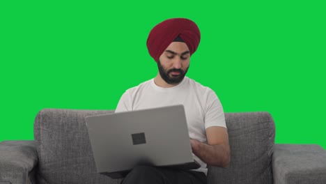 Sikh-Indian-manager-doing-video-call-on-Laptop-Green-screen