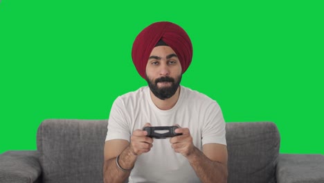 Wettbewerbsfähiger-Sikh-Indianer,-Der-Videospiele-Auf-Grünem-Bildschirm-Spielt
