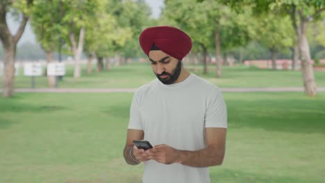 Wütender-Sikh-Indianer,-Der-Jemandem-Im-Park-Eine-SMS-Schreibt