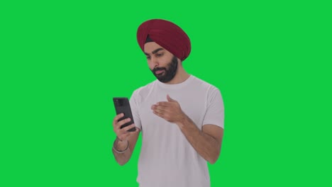Wütender-Sikh-Indianer,-Der-über-Einen-Videoanruf-Mit-Grünem-Bildschirm-Spricht