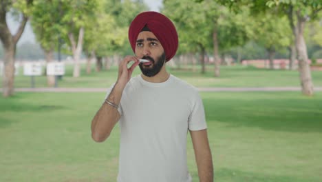 Sick-Sikh-Indian-man-using-thermometer-to-check-fever-in-park