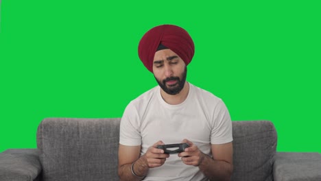 Schläfriger-Und-Müder-Sikh-Indianer,-Der-Videospiele-Auf-Grünem-Bildschirm-Spielt
