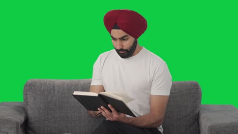 Sikh-Indian-man-reading-book-and-drinking-tea-Green-screen