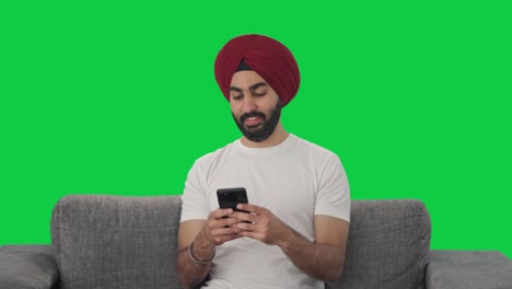 Fröhlicher-Sikh-Indianer,-Der-Mit-Jemandem-Auf-Grünem-Bildschirm-Chattet