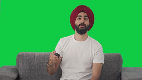Glücklicher-Indischer-Sikh-Mann,-Der-Fernsieht,-Grüner-Bildschirm