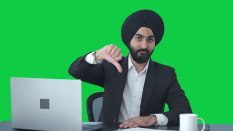 Desilusionado-Empresario-Indio-Sikh-Mostrando-Los-Pulgares-Hacia-Abajo-En-La-Pantalla-Verde