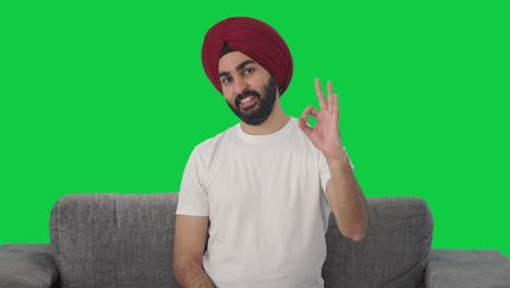 Fröhlicher-Sikh-Indianer-Mit-Grünem-Bildschirm,-Der-Ein-Okay-Schild-Zeigt