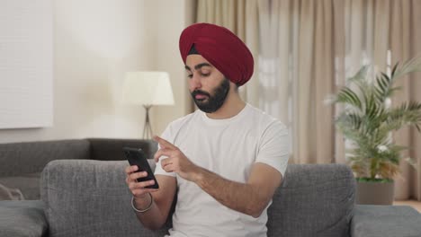 Schläfriger-Sikh-Indianer,-Der-Sein-Mobiltelefon-Benutzt