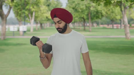 Sikh-Indian-man-lifting-heavy-dumbbells-in-park