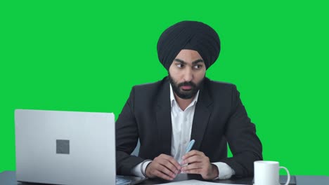 Ernsthafter-Indischer-Sikh-Geschäftsmann,-Der-Mit-Jemandem-Auf-Grünem-Bildschirm-Spricht