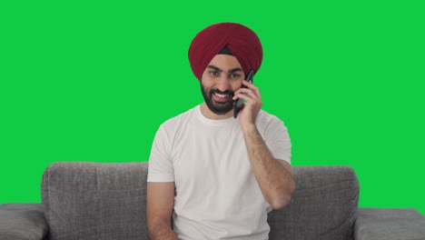 Fröhlicher-Sikh-Indianer,-Der-Auf-Dem-Grünen-Bildschirm-Des-Telefons-Spricht