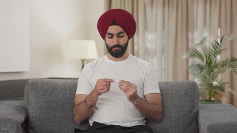 Sick-Sikh-Indian-man-using-thermometer-to-check-fever