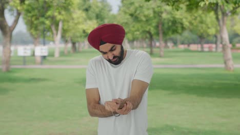 Hombre-Indio-Sikh-Enfermo-Que-Sufre-De-Dolor-En-La-Mano-En-El-Parque