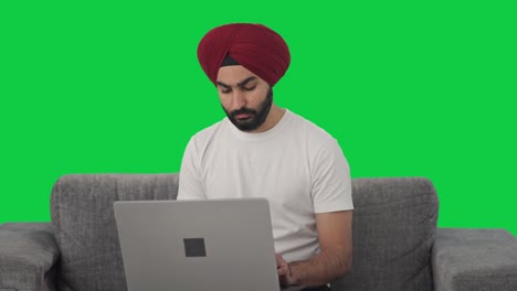 Serious-Sikh-Indian-man-using-Laptop-Green-screen