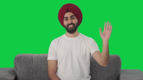 Fröhlicher-Sikh-Indianer-Winkt-Zum-Grünen-Bildschirm-Der-Kamera