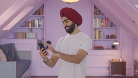 Feliz-Hombre-Indio-Sikh-Desplazándose-Por-Teléfono
